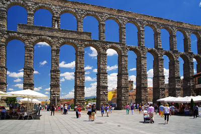People at aqueduct of segovia in city