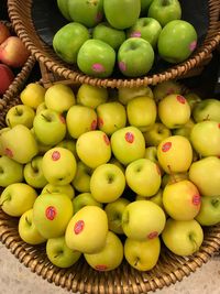 High angle view of apples in basket for sale at market stall