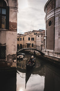 Canal amidst buildings against sky in city