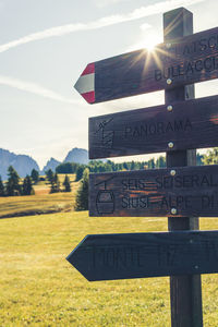 Information sign on field against sky