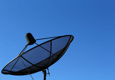 Low angle view of satellite dish against clear blue sky