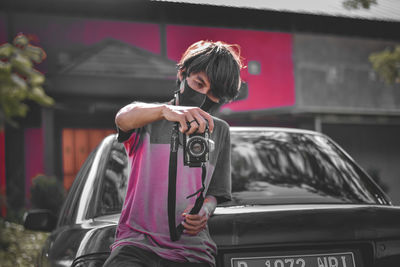 Full length of woman photographing car