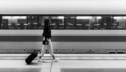 Rear view of woman standing on tiled floor