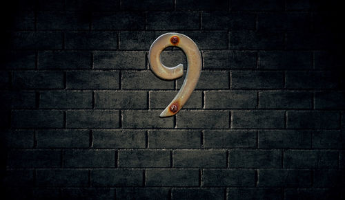 Number 9 on brick wall at night