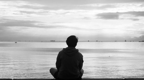 Rear view of silhouette man standing at beach