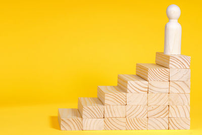 Close-up of wooden toy blocks against yellow background