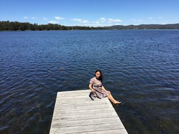 Full length of woman on pier over lake against sky