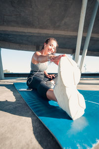 Portrait of young woman sitting on poolside