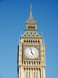 Low angle view of clock tower against blue sky