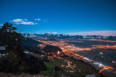 High angle view of illuminated cityscape against sky at night