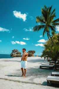 Full length of man standing at beach against sky