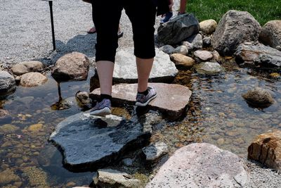 Low section of man standing on rocks