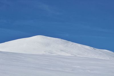 Snowcapped mountains against blue sky