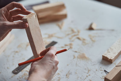 Cropped hands of carpenter holding wood at workshop