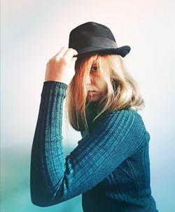 Portrait of woman wearing hat against white background