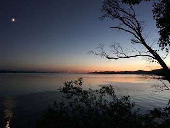 Scenic view of lake against sky at sunset