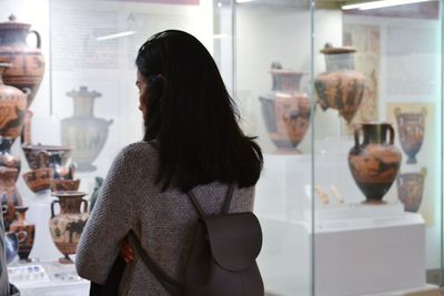 Rear view of woman standing in glass