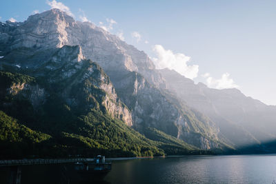 Scenic view of lake by mountains against sky