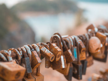 Close-up of padlocks hanging on rusty metal