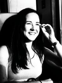 Portrait of a smiling young woman sitting at home