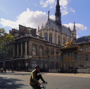 People on street against buildings in city