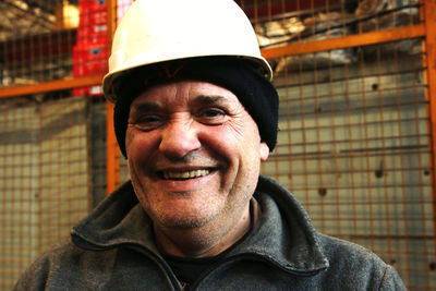 Portrait of smiling man wearing hardhat in factory