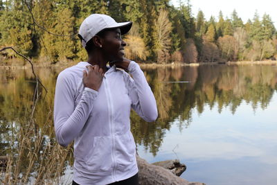 Smiling mid adult woman standing by lake with reflection