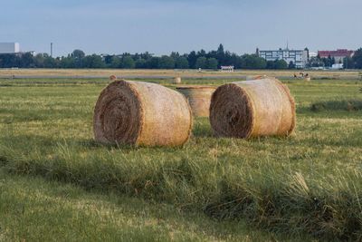 Hay bales on field against sky