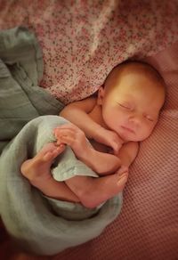 High angle view of cute baby girl sleeping on bed