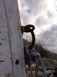 Close-up of rusty metal against cloudy sky