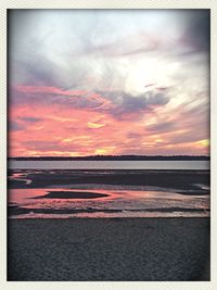 Scenic view of sea against cloudy sky at sunset