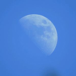 Low angle view of moon against blue sky