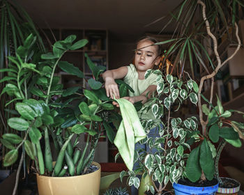 Young woman standing by potted plants