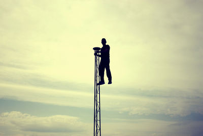 Low angle view of pole against cloudy sky