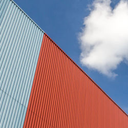 Low angle view of metallic wall against the sky