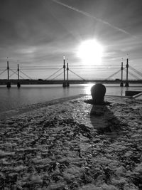 Bridge over river at sunset