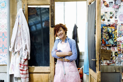 Smiling female artisan in doorway of studio