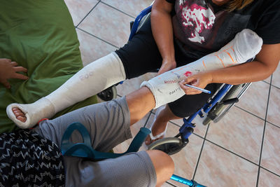 Low section of mother and son with fractured leg sitting in hospital