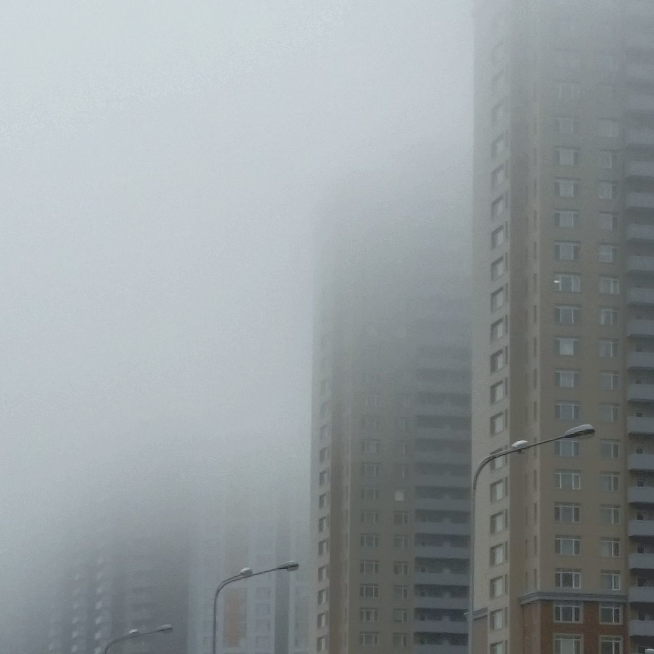 architecture, building exterior, built structure, fog, city, skyscraper, foggy, tall - high, modern, weather, office building, tower, building, cityscape, glass - material, sky, day, window, no people, residential building