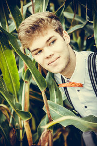 Portrait of young man with leaves outdoors