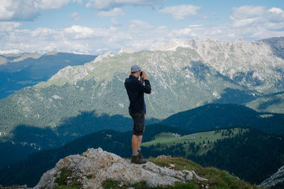 Full length of man standing on rock against mountains