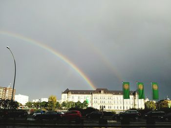 Rainbow over city against sky