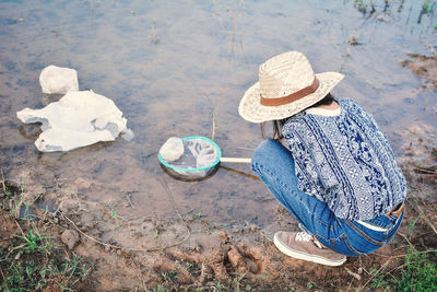 Rear view of woman picking up garbage