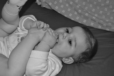 High angle view of baby lying on bed