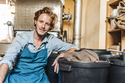 Portrait of smiling coffee roaster in his shop