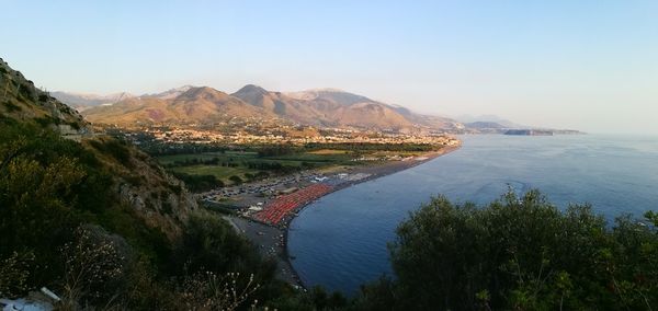 Scenic view of river by mountains against clear sky