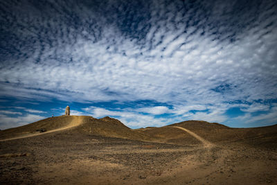 View of desert against cloudy sky