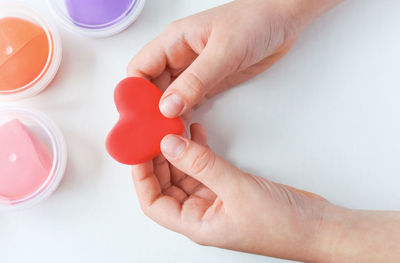 The child's hands hold a heart made of plasticine. an expression of love and affection.