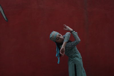 Woman dancing against wall