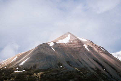 Low angle view of snowcapped mountain against sky